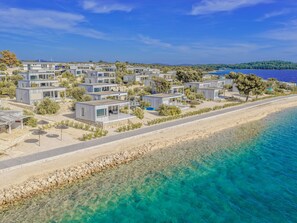 A coastal resort with modern cabins, clear turquoise waters, and a sandy beach. - Buqez - Villa 27 by Interhome (Pakoštane/Drage)