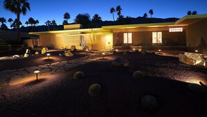 A modern house with a stone pathway, palm trees, and outdoor lighting. - Star of Modernism Week - Three Bedrooms, Pool &Spa in Historic Deepwell Estates (Palm Springs)