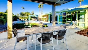 An outdoor patio with a pool, dining area, and covered seating. - Star of Modernism Week - Three Bedrooms, Pool &Spa in Historic Deepwell Estates (Palm Springs)