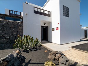 A modern two-story building with a stone wall and a cactus garden. - Casa OASIS DEL SOL, prívate villa in Playa Blanca by Interhome (Playa Blanca)