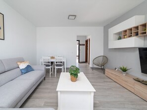 A modern living room with a grey sofa, a white coffee table, and a dining area with a white table and chairs. - Casa OASIS DEL SOL, prívate villa in Playa Blanca by Interhome (Playa Blanca)