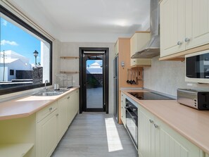 A modern kitchen with a view to the outside, a built-in oven, and a microwave. - Casa OASIS DEL SOL, prívate villa in Playa Blanca by Interhome (Playa Blanca)