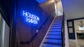 En trappe med et neon-skilt, der viser 'Houston Haalen', og et moderne interiørdesign.