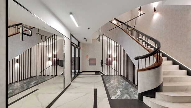 A modern interior with a marble floor, a spiral staircase, and a glass elevator. - Plac Unii by Grand Apartments (Gdynia)