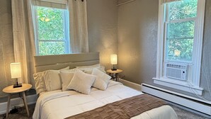 A bedroom with a bed, two bedside tables, a ceiling fan, and two windows with curtains. - Cozy Private 1BR in the Heart of 5 Points (Denver)
