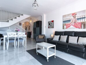 A modern living room with a staircase, a dining area, and a sofa. - Fuentesol Casa Ekman by Casasol by Interhome (Nerja)