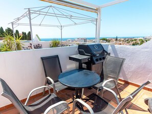 A rooftop terrace with a grill, a table, and four chairs. - Fuentesol Casa Ekman by Casasol by Interhome (Nerja)