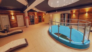 Un'area benessere con piscina, cabine per massaggi e una reception.