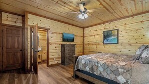 A wooden-paneled bedroom with a bed, dresser, and a ceiling fan. - Sleeps 20 | Private Indoor Pool, Theater, Arcade (Sevierville)