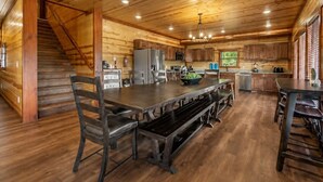 A spacious kitchen with wooden cabinets, a central island, and a dining area with benches. - Sleeps 20 | Private Indoor Pool, Theater, Arcade (Sevierville)
