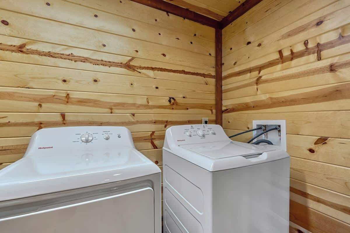 Ein Waschraum mit zwei weißen Waschmaschinen und einer Holzwand.