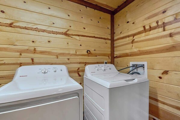 Ein Waschraum mit zwei weißen Waschmaschinen und einer Holzwand.