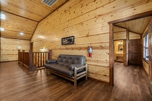 Ein Holzinterieur mit einem Ledersofa, einem Feuerlöscher und einem gerahmten Bild an der Wand.