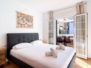 A hotel room with a large bed, a map artwork, a view of the outside, and a balcony with chairs. - Apartment  by Interhome (Nerja)