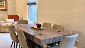 En matplats med ett träbord, sex stolar och ett fönster med persienner.