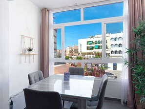 A hotel room with a large window, a table, and chairs. - Apartment  by Interhome (Nerja)