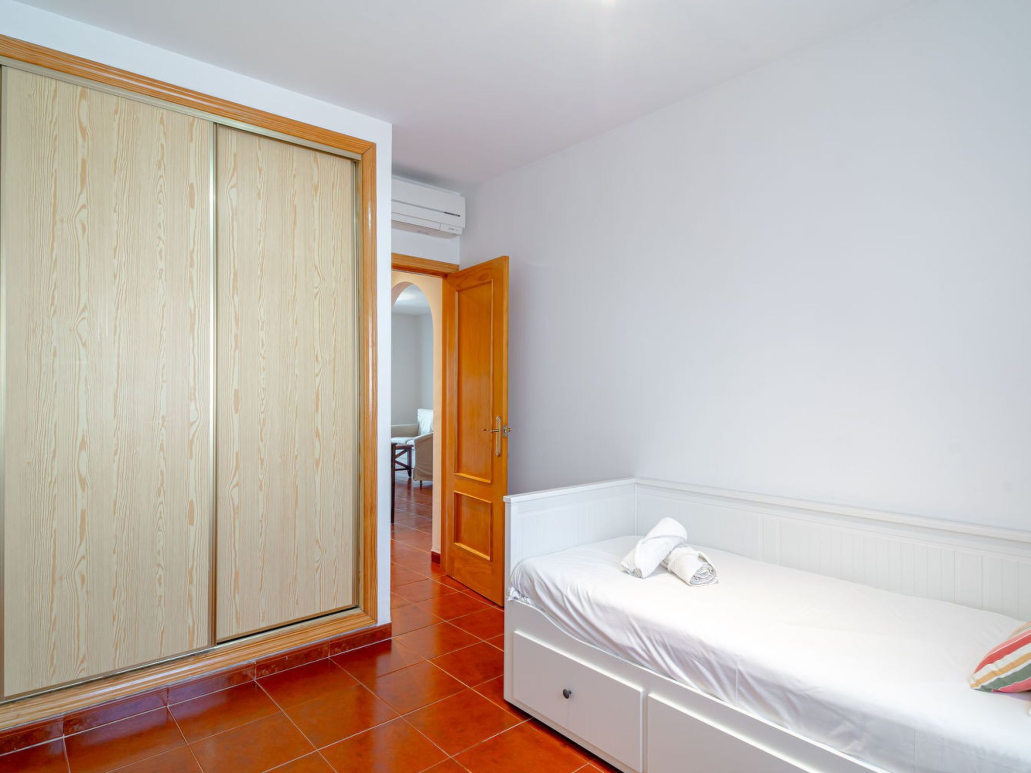 Un dormitorio con cama, armario y baño a la vista.