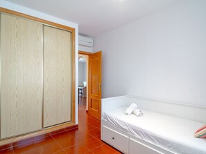 A bedroom with a bed, a wardrobe, and a bathroom visible in the background. - Apartment  by Interhome (Nerja)