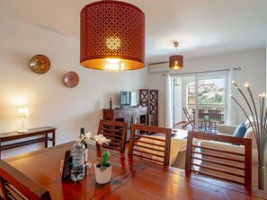 Ein Essbereich mit Holztisch, Stühlen, einer Wasserflasche und einem Blumentopf.