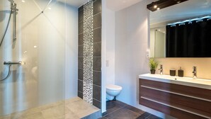 Ein modernes Badezimmer mit Dusche, Toilette und Waschtisch.