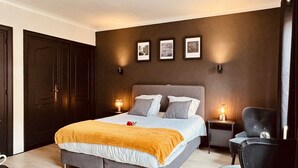 Ein Schlafzimmer mit Bett, Nachttischen, einem Sessel und einem Kleiderschrank.
