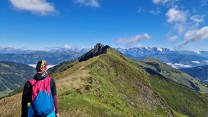 A hiker on a mountain trail with a clear sky and distant mountain peaks. - Apartment  by Interhome (Rauris)