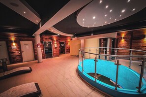 A hotel lobby with a swimming pool, a reception desk, and a staircase leading to the upper floor. - Schönblick - Martina 4 by Interhome (Rauris)