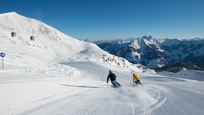 A snowy ski slope with skiers, a ski lift, and a mountain backdrop. - Apartment  by Interhome (Rauris)
