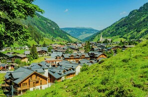 A village with traditional wooden houses, a church, and a valley. - Schönblick - Martina 4 by Interhome (Rauris)