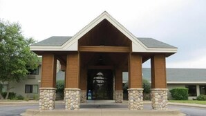 A building with a covered entrance, stone pillars, and a pitched roof. - Super Davneport Inn & Suite (Davenport)