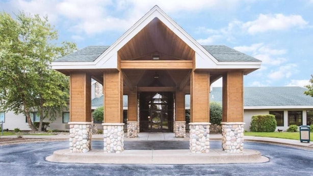 A building with a covered entrance, stone pillars, and a triangular roof. - Super Davneport Inn & Suite (Davenport)
