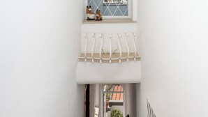 A narrow stairway leading to a balcony with a window overlooking a residential area. - De Vivo Realty - The Colombo Positano (Positano)