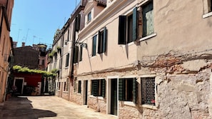 A narrow street with historic buildings, some with visible brickwork and traditional shutters. - Cà Livia by Venicescape (Venice)