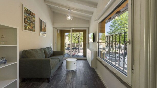A narrow hallway with a sofa, a small table, and a window with a view of the street. - Vettori Hideaway by MMega Homes and Villas (Florence)