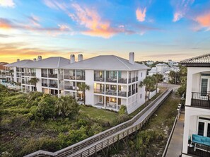 A multi-story hotel with balconies, a pool area, and a view of the surrounding landscape. - Beachfront Condo w/ Community Pool and Elevator (Santa Rosa Beach)