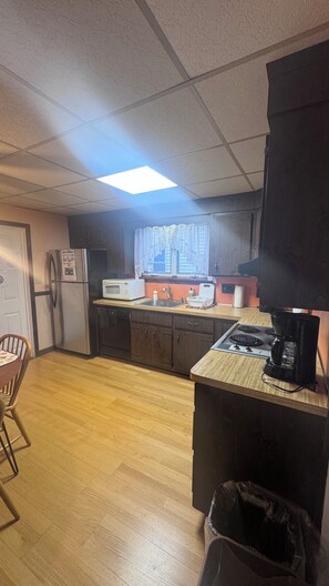 A compact kitchen with a refrigerator, microwave, sink, and stove. - Inviting 1BR Near Boston -- Easy Transit -- Parking Included (Malden)