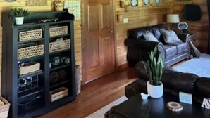Ein Holzinnenraum mit Treppe, einer Couch, einem Couchtisch und Wanddekorationen.