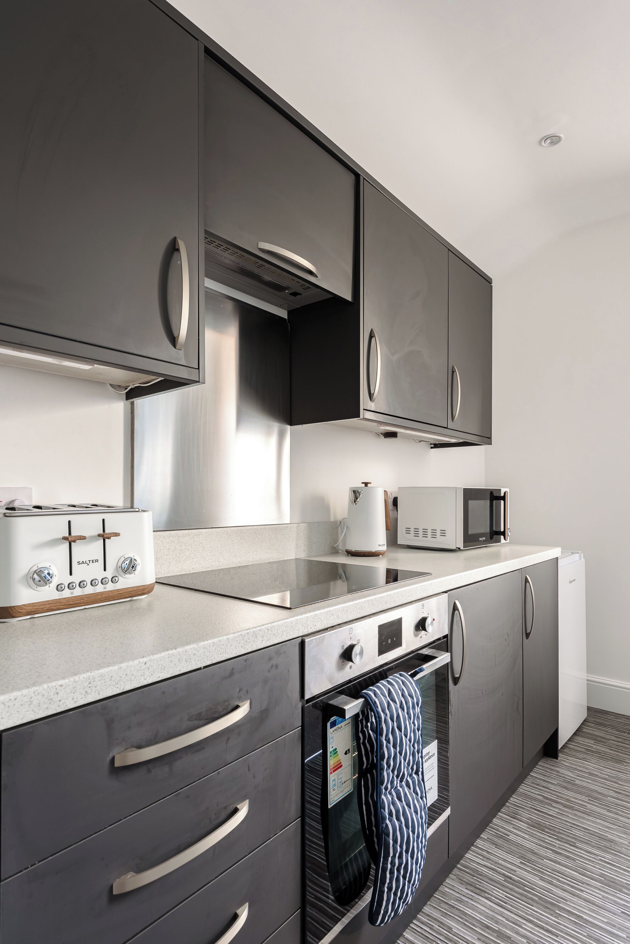 A modern kitchen with stainless steel appliances, a built-in oven, and a microwave.