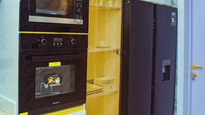 Eine Küche mit Mikrowelle, Backofen und Kühlschrank.