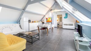 A modern loft-style apartment with a dining area, kitchen, and living space.