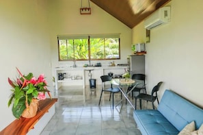 Una cocina moderna con comedor, un sofá azul y una planta en maceta.