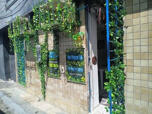 A building with ivy-covered walls and two signs advertising a bed and breakfast.