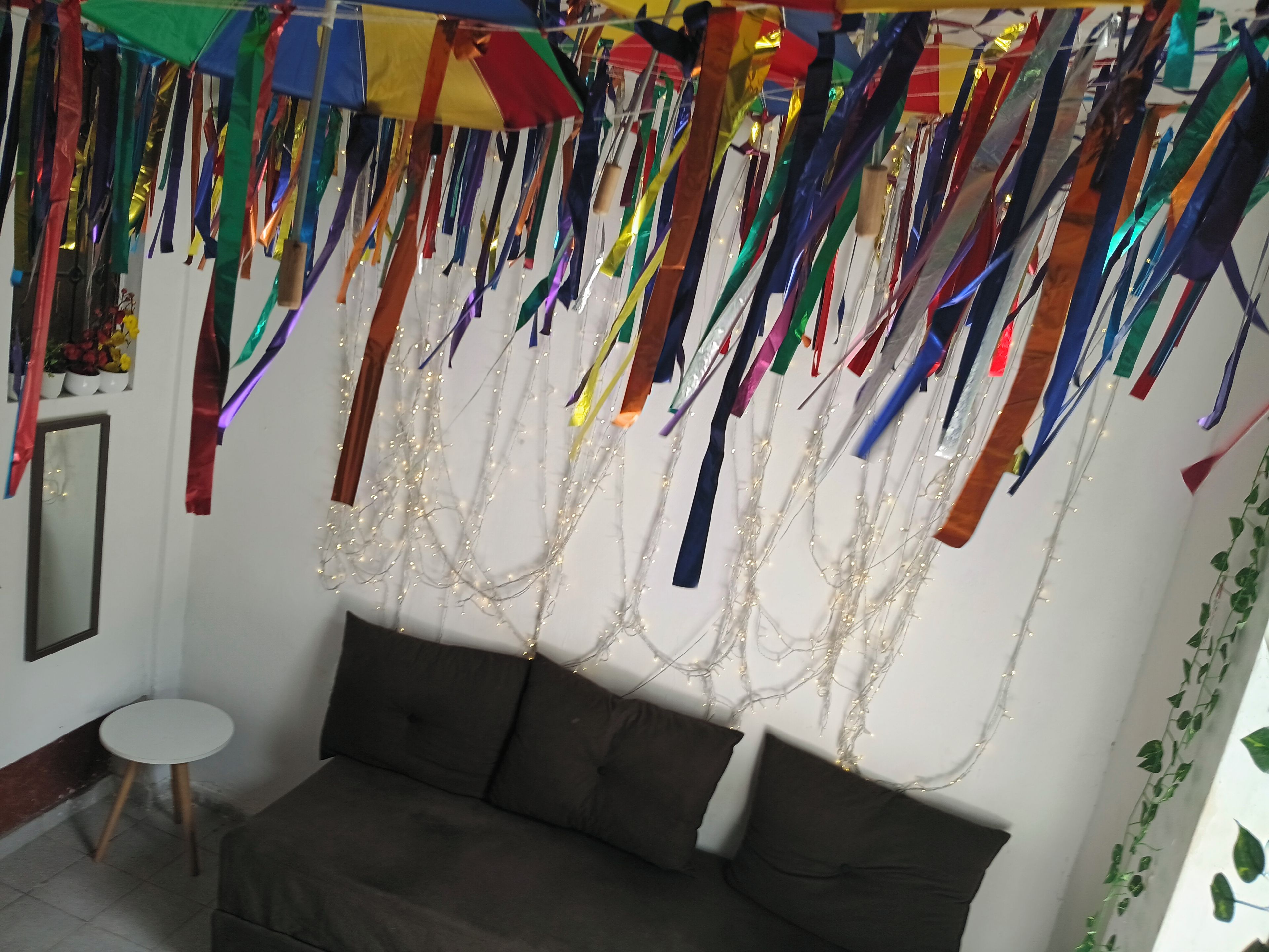 Una habitación con sofá, una mesita y un espejo.
