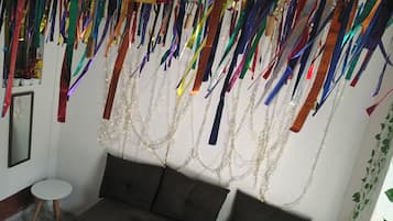 Una habitación con sofá, una mesita y un espejo.