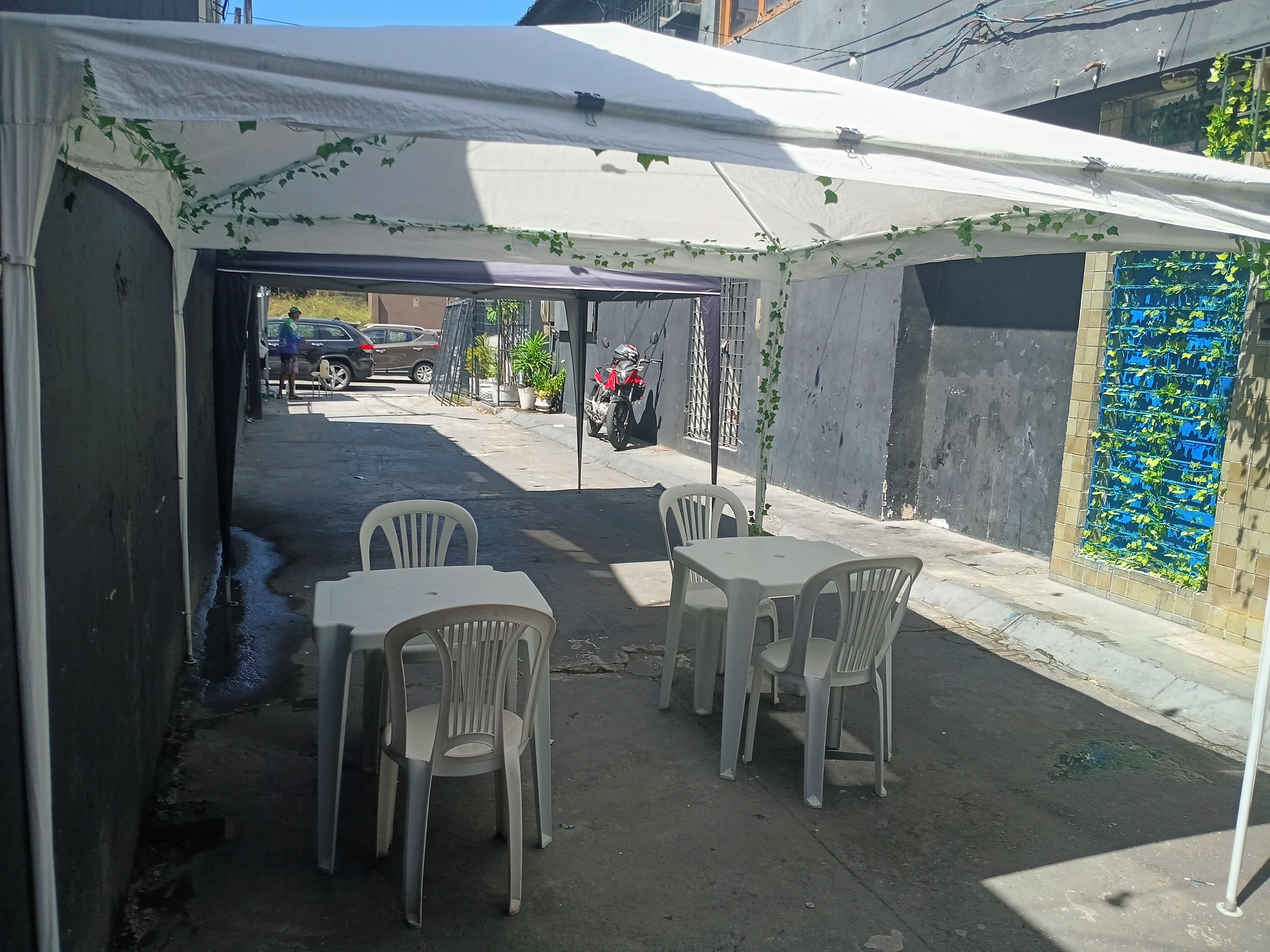 Un área de estar al aire libre con una mesa y sillas bajo una carpa.