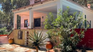 Un edificio de dos plantas con un balcón, una puerta y una ventana.