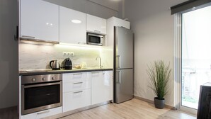 Een moderne keuken met witte kastjes, roestvrijstalen apparatuur, een magnetron en een koelkast.