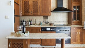 A kitchen with wooden cabinets, a dishwasher, a stove, and a sink. - Apartment 'Estrella Del Guadalquivir' with Shared Pool, Wi-Fi and Air Conditioning (Arroyo Frio)
