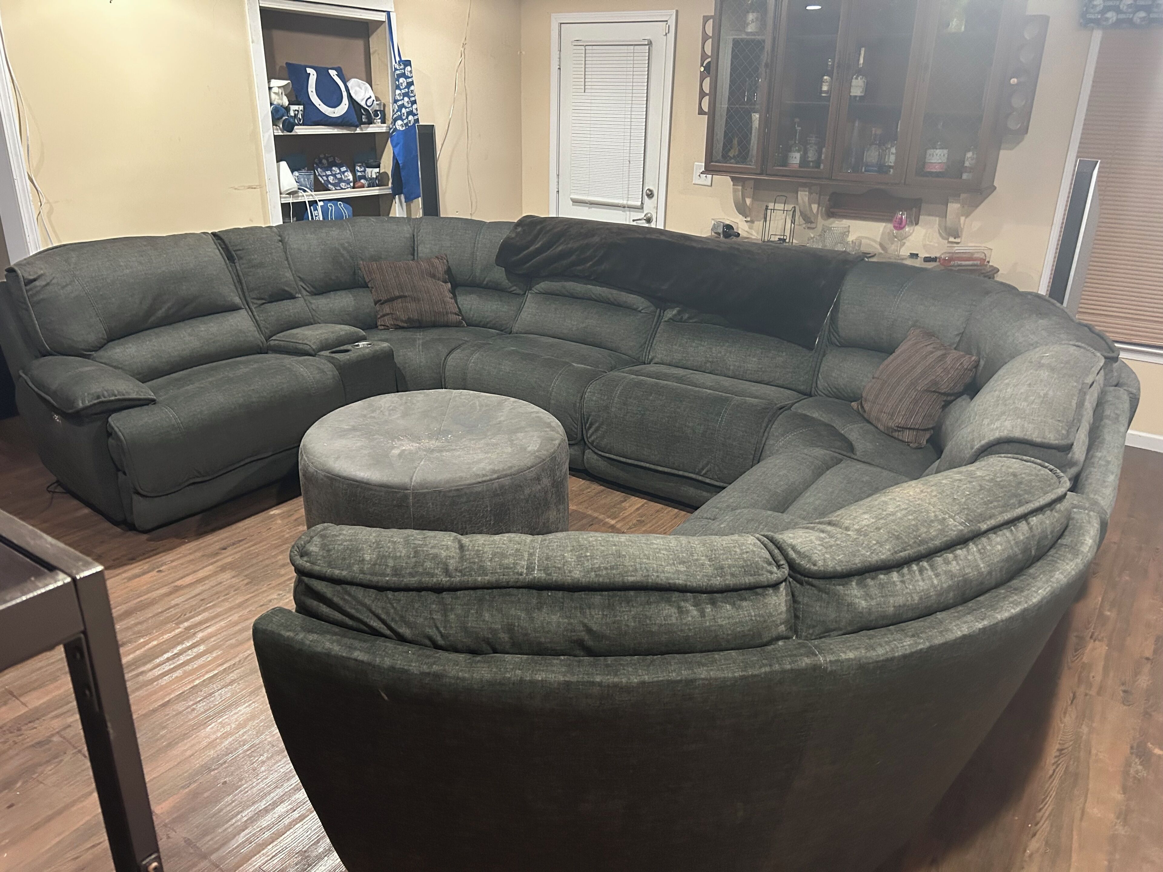 Un canapé modulable avec un pouf rond dans un salon.