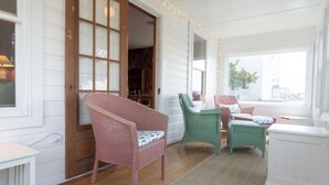 Una habitación con piso de madera, un ventanal grande y una puerta con paneles de vidrio.